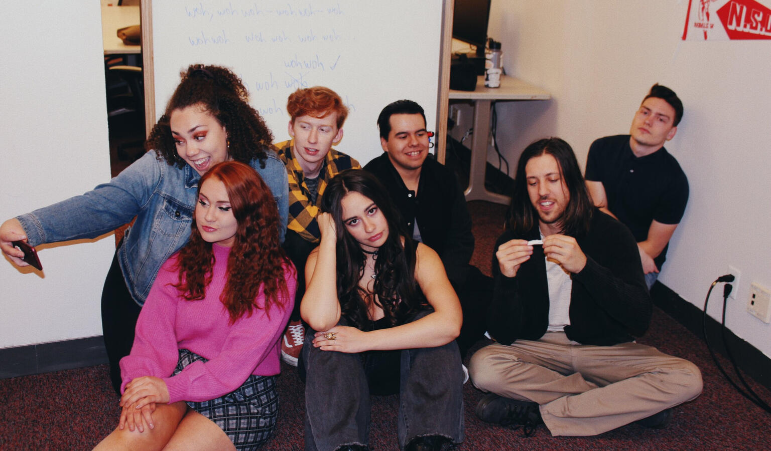 A group of teenagers, based off the Peanut's characters sitting on the floor.