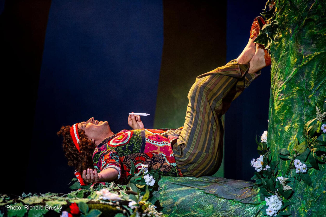 Puck, a hippie fairy, is smoking a joint laying on a giant tree.